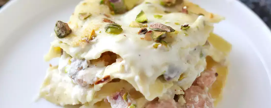 Lososova lazanja z burrato in kremnimi, hrustljavimi pistacijami