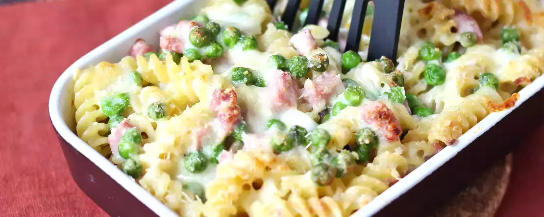 Kremno pečene testenine z grahom in šunko au gratin