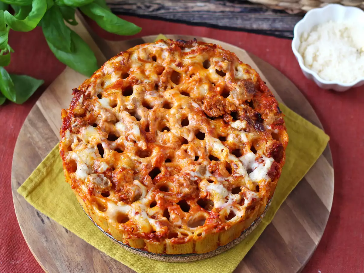 Pečen timballo iz rigatoni s klobaso, bešamelom in mozzarello